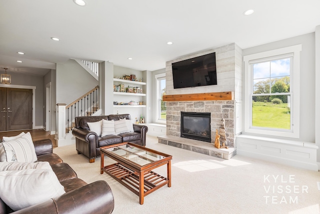 11650 Lally St NE, Lowell, MI 49331 - carpeted living room with stairway, recessed lighting, a stone fireplace, and built in shelves