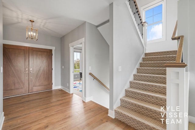 11650 Lally St NE, Lowell, MI 49331 - entrance foyer featuring light wood-style flooring, a chandelier, baseboards, and stairway