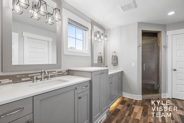 11650 Lally St NE, Lowell, MI 49331 - bathroom with a shower stall, baseboards, wood finished floors, recessed lighting, and two vanities