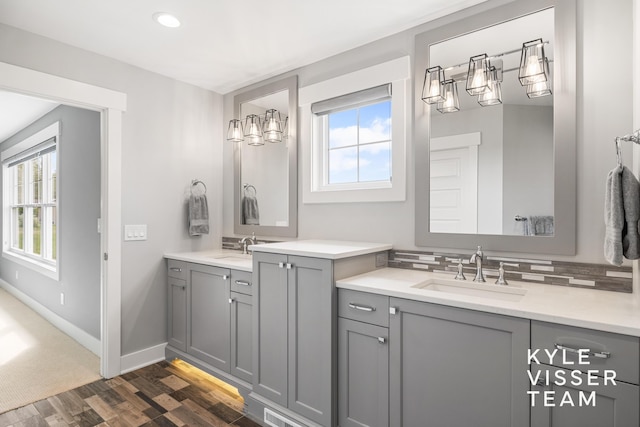 11650 Lally St NE, Lowell, MI 49331 - bathroom featuring plenty of natural light, wood finished floors, two vanities, baseboards, and recessed lighting
