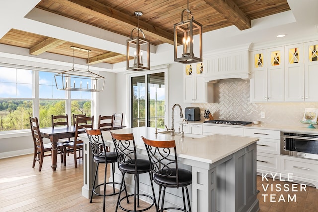 11650 Lally St NE, Lowell, MI 49331 - kitchen with wooden ceiling, stainless steel gas stovetop, beamed ceiling, a chandelier, and light countertops