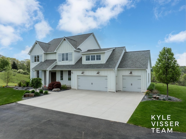 11650 Lally St NE, Lowell, MI 49331 - view of front facade with board and batten siding, a shingled roof, concrete driveway, and a front lawn