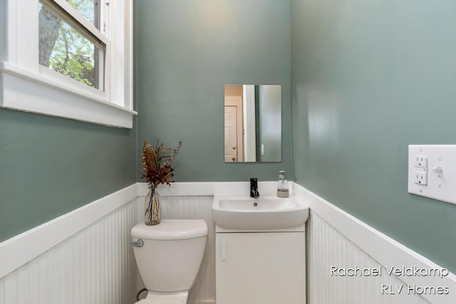 bathroom with wainscoting, toilet, and vanity