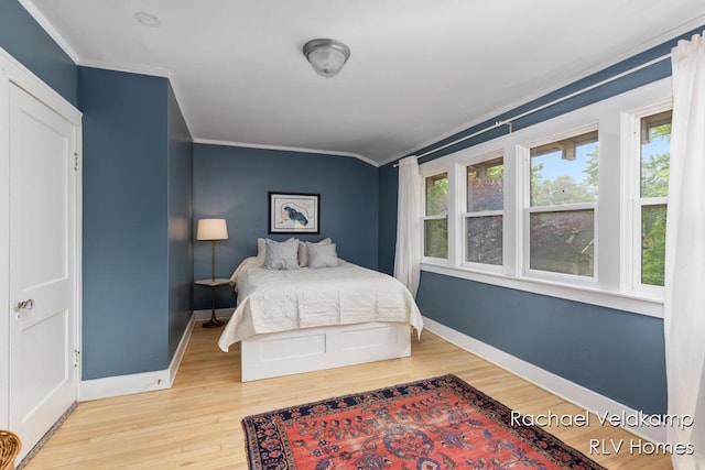 bedroom featuring crown molding, wood finished floors, and baseboards