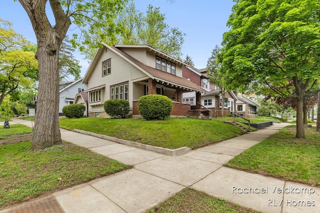 view of front of property featuring a front yard and brick siding