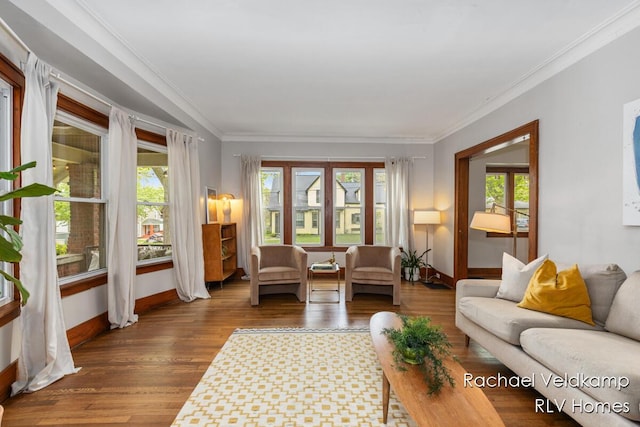 living area with healthy amount of natural light, baseboards, ornamental molding, and wood finished floors