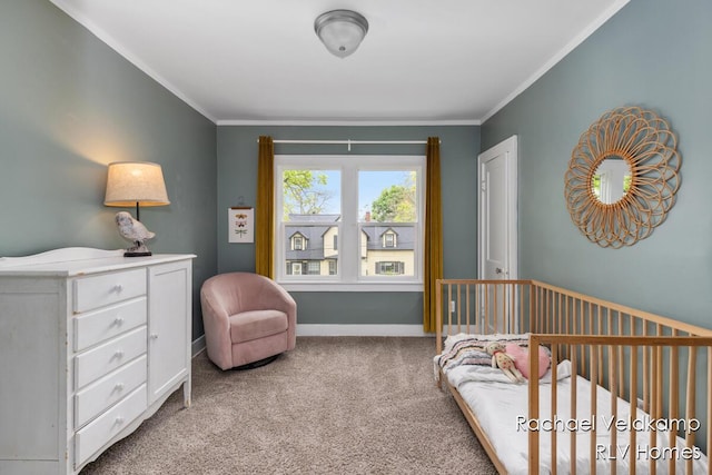bedroom featuring carpet flooring, crown molding, a crib, and baseboards