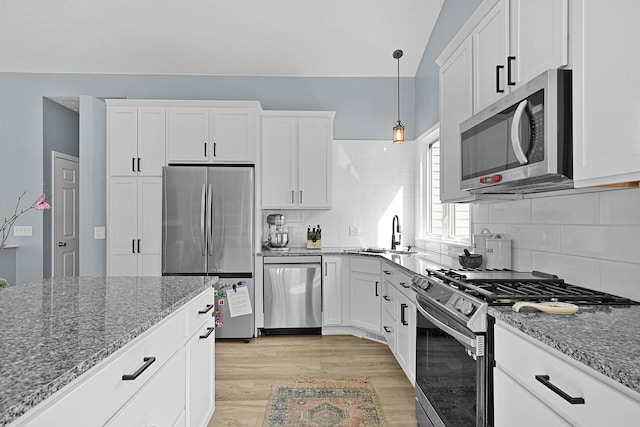 12700 Mcpherson St NE, Lowell, MI 49331 - kitchen with appliances with stainless steel finishes, a sink, dark stone countertops, and light wood finished floors