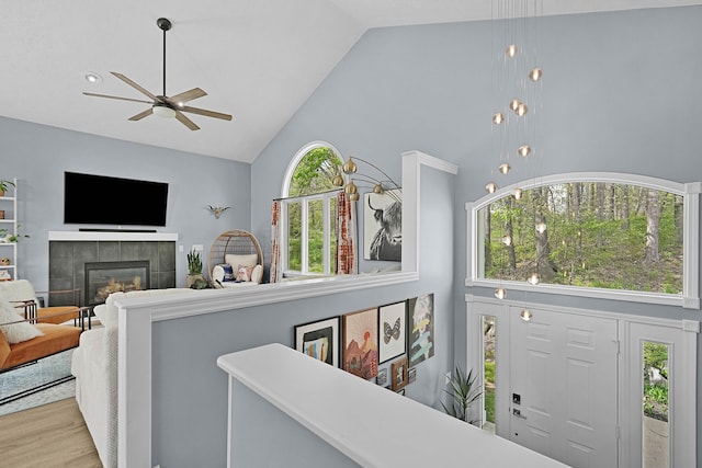 12700 Mcpherson St NE, Lowell, MI 49331 - living area featuring high vaulted ceiling, plenty of natural light, ceiling fan, a tile fireplace, and wood finished floors