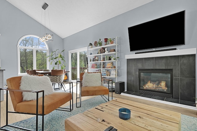 12700 Mcpherson St NE, Lowell, MI 49331 - living room with wood finished floors, high vaulted ceiling, a tile fireplace, and healthy amount of natural light