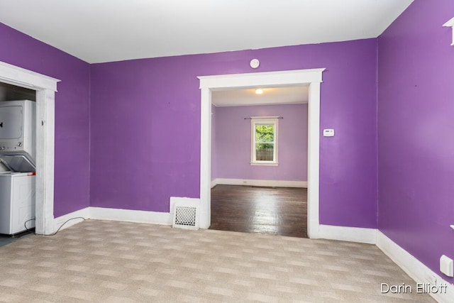 412 Breens Ct SW, Grand Rapids, MI 49503 - carpeted empty room featuring stacked washer and clothes dryer and baseboards
