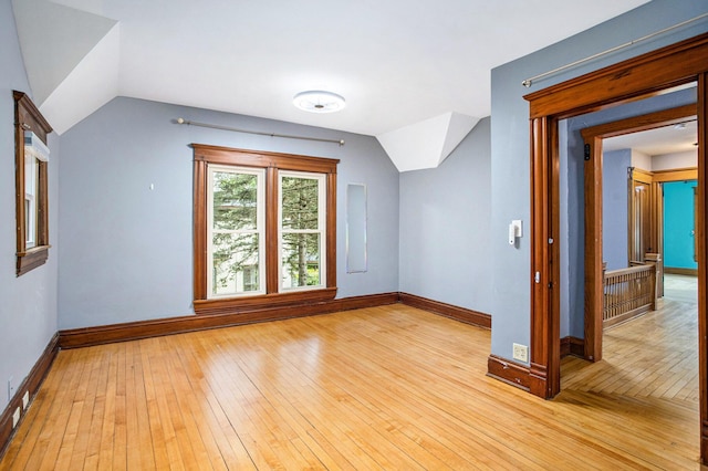 bonus room featuring light wood finished floors, vaulted ceiling, and baseboards