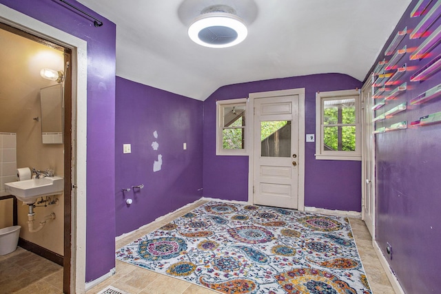 foyer with lofted ceiling and baseboards
