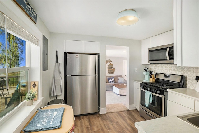 3957 Cleveland Dr W, Bitely, MI 49309 - kitchen with appliances with stainless steel finishes, wood finished floors, light countertops, white cabinets, and electric panel