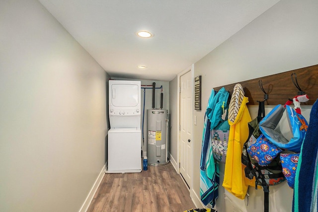 3957 Cleveland Dr W, Bitely, MI 49309 - laundry area with electric water heater, estacked washer and dryer, baseboards, wood finished floors, and recessed lighting
