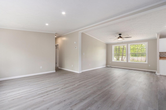 unfurnished living room with a ceiling fan, crown molding, wood finished floors, baseboards, and a textured ceiling