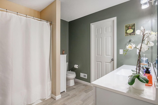 7762 Sierra Dr, Belding, MI 48809 - full bath featuring toilet, wood finished floors, baseboards, and vanity