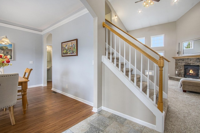 14275 Sunset Ridge Ct, Niles, MI 49120 - staircase with arched walkways, baseboards, a stone fireplace, ceiling fan, and crown molding