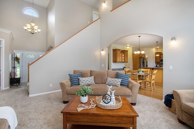 14275 Sunset Ridge Ct, Niles, MI 49120 - living room with a chandelier, a towering ceiling, arched walkways, light carpet, and baseboards