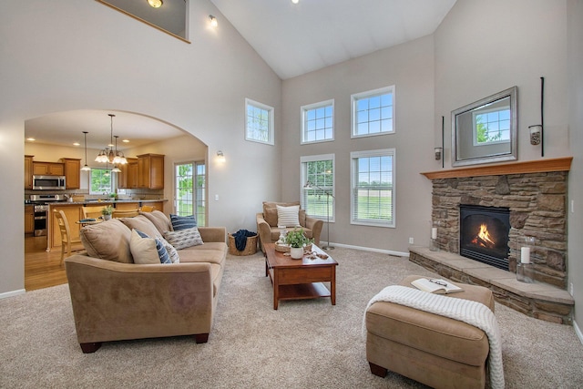 14275 Sunset Ridge Ct, Niles, MI 49120 - living room with high vaulted ceiling, light colored carpet, arched walkways, a fireplace, and baseboards