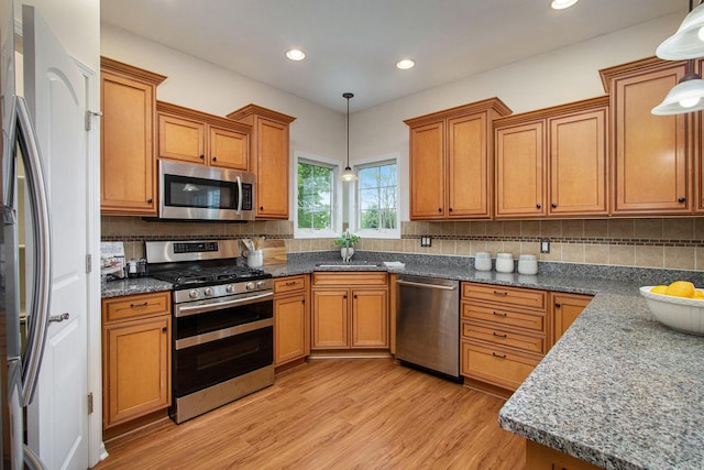 14275 Sunset Ridge Ct, Niles, MI 49120 - kitchen with stainless steel appliances, light wood finished floors, brown cabinetry, decorative backsplash, and recessed lighting