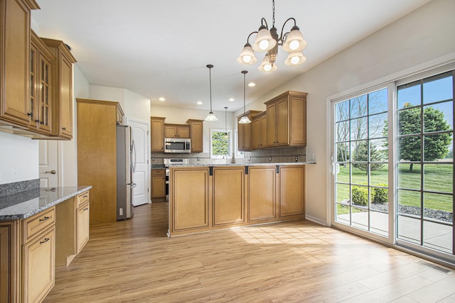 14275 Sunset Ridge Ct, Niles, MI 49120 - kitchen with stainless steel appliances, a chandelier, light wood finished floors, brown cabinetry, and recessed lighting