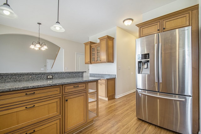 14275 Sunset Ridge Ct, Niles, MI 49120 - kitchen featuring stainless steel fridge with ice dispenser, brown cabinetry, light wood-style floors, hanging light fixtures, and arched walkways