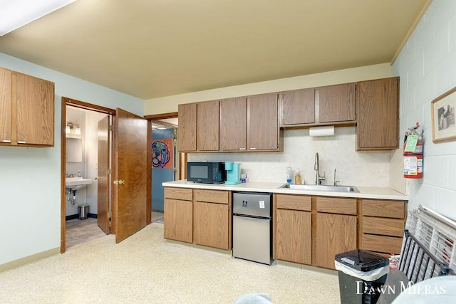 7795 Douglas Ave, Kalamazoo, MI 49009 - kitchen with a sink, fridge, black microwave, and light countertops