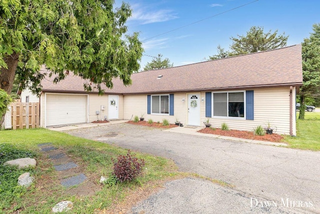 7795 Douglas Ave, Kalamazoo, MI 49009 - ranch-style home featuring fence, asphalt driveway, a garage, and roof with shingles