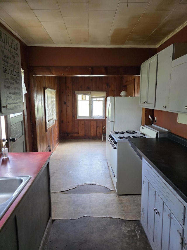 120 2nd St, Ionia, MI 48846 - kitchen with white appliances, wooden walls, a sink, and white cabinetry