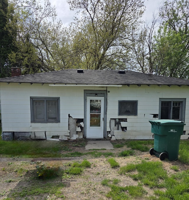 120 2nd St, Ionia, MI 48846 - rear view of house with a shingled roof and a chimney