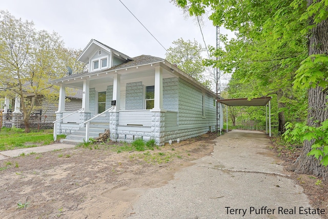 view of front of house with a carport, concrete driveway, and covered porch
