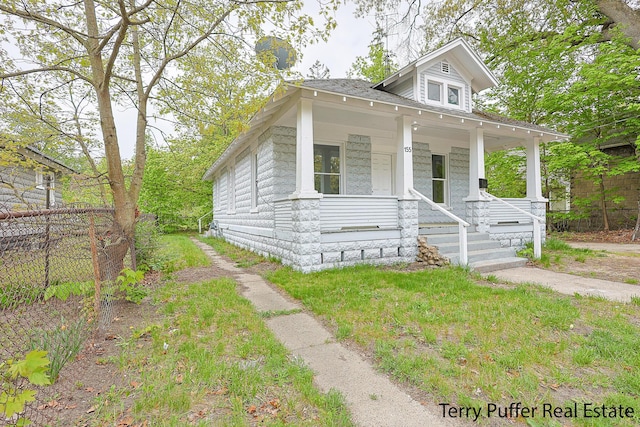 view of front of property with a porch and fence