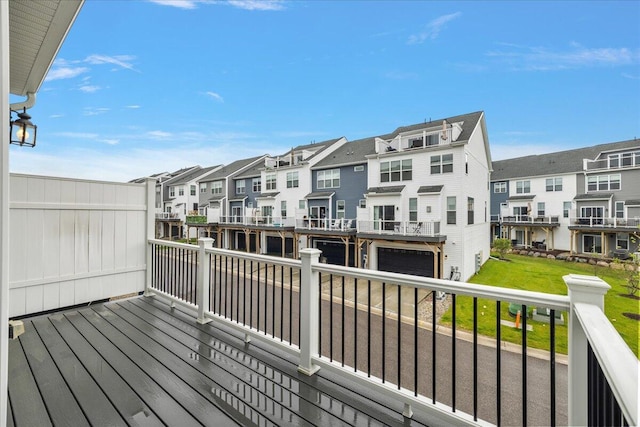 wooden terrace with a residential view and an attached garage