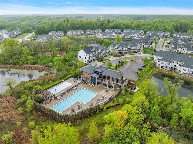 aerial perspective of suburban area featuring a pool area and a nearby body of water
