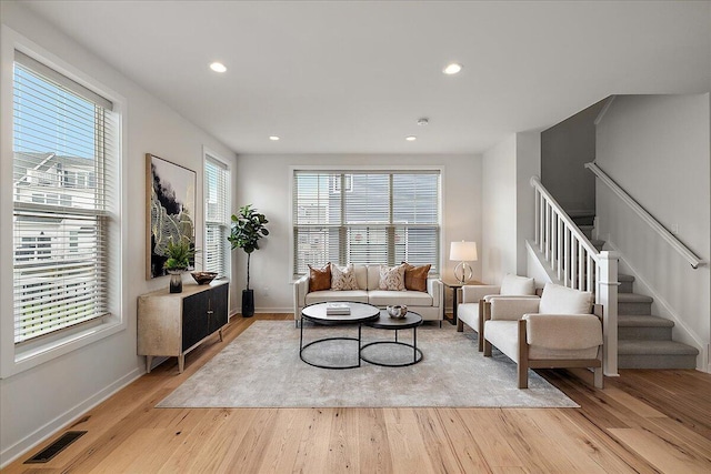 living room featuring light wood finished floors, stairway, recessed lighting, and baseboards