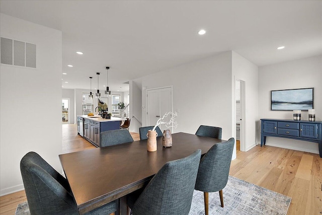 dining space with light wood-style flooring, recessed lighting, and baseboards