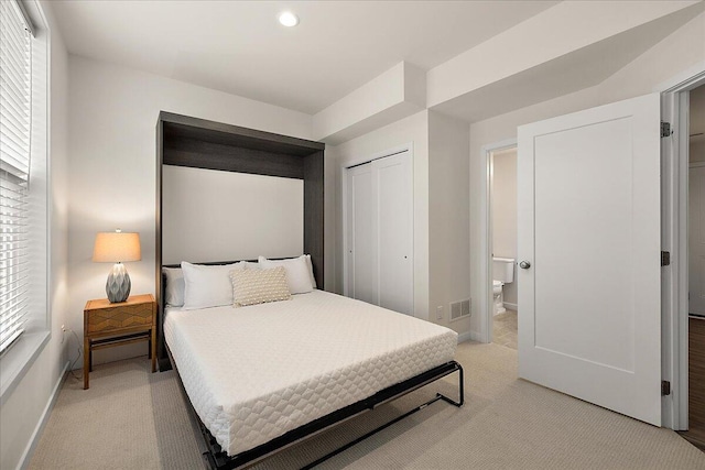 bedroom featuring light colored carpet, baseboards, a closet, recessed lighting, and connected bathroom