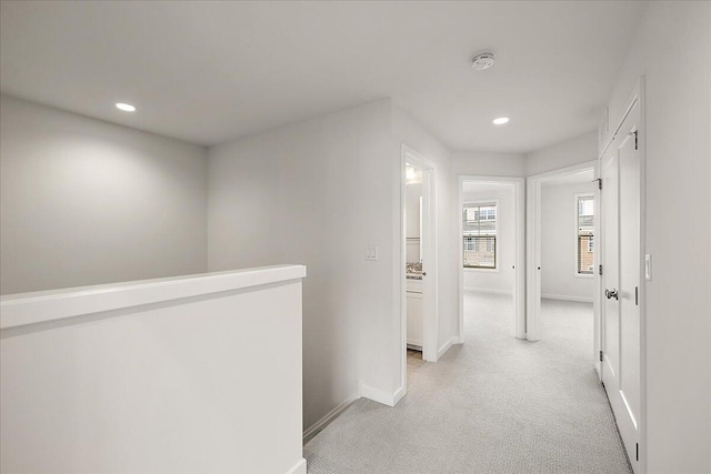 corridor featuring recessed lighting, light carpet, baseboards, and an upstairs landing