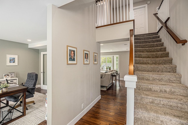 stairway with wood finished floors, baseboards, and recessed lighting