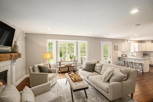 living room with a fireplace, recessed lighting, dark wood-style floors, and baseboards