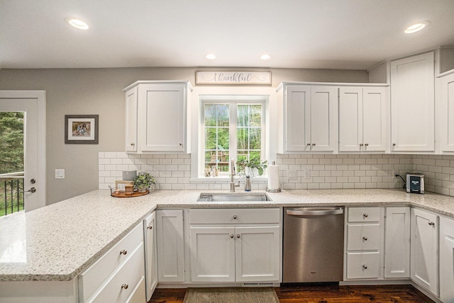 kitchen with dishwasher, a sink, a peninsula, white cabinets, and recessed lighting
