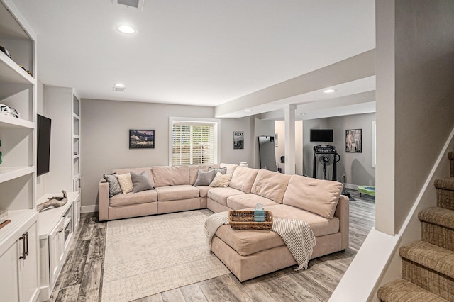 living room with light wood-type flooring, recessed lighting, and stairway