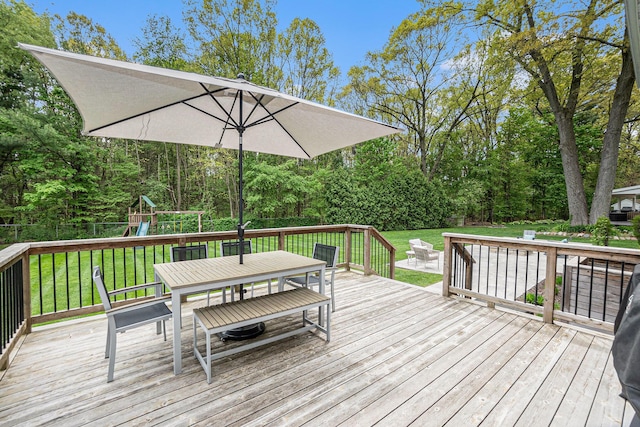 deck featuring outdoor dining space and a playground