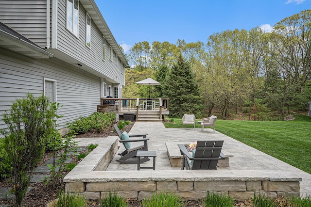 view of patio / terrace with a deck and a fire pit