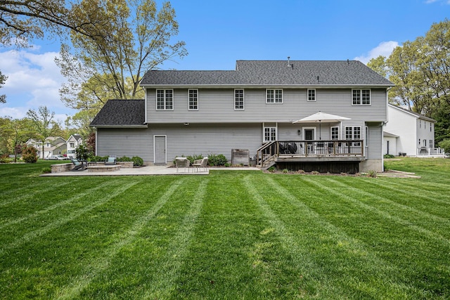 back of house with a patio, a deck, a lawn, and a shingled roof