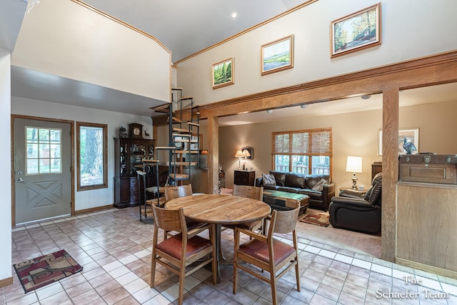10436 Morgan Mills Ave NE, Greenville, MI 48838 - dining area with light tile patterned floors, a towering ceiling, ornamental molding, and baseboards