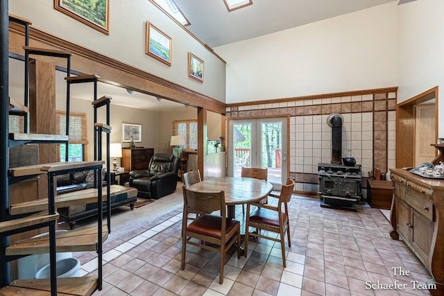 10436 Morgan Mills Ave NE, Greenville, MI 48838 - dining room with a towering ceiling, a wood stove, and light tile patterned floors