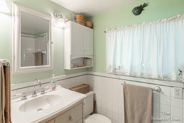 10436 Morgan Mills Ave NE, Greenville, MI 48838 - bathroom with tile walls, toilet, vanity, and a wainscoted wall