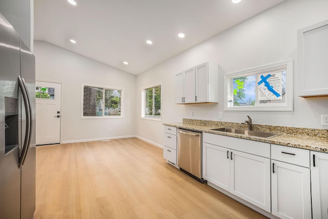 kitchen with appliances with stainless steel finishes, light wood-type flooring, a sink, recessed lighting, and lofted ceiling
